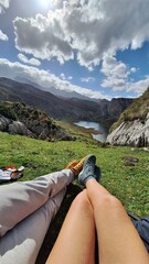 couple of people showing their feet in front of the lake and the mountains