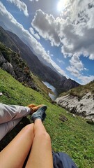 couple of people showing their feet in front of the lake and the mountains
