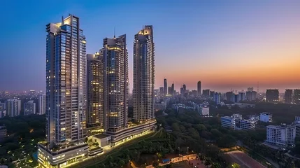 High-rise commercial buildings in Gurgaon, India, during dusk with lights illuminating the skyline.