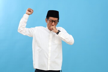 Naklejka premium Asian muslim man standing while yawning. Sleepy in ramadan month concept