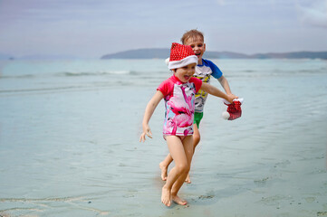 kids in Santa hat on the beach