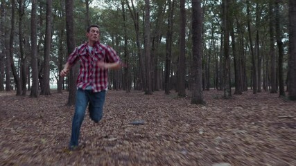 Fearful man running away from something in dark forest