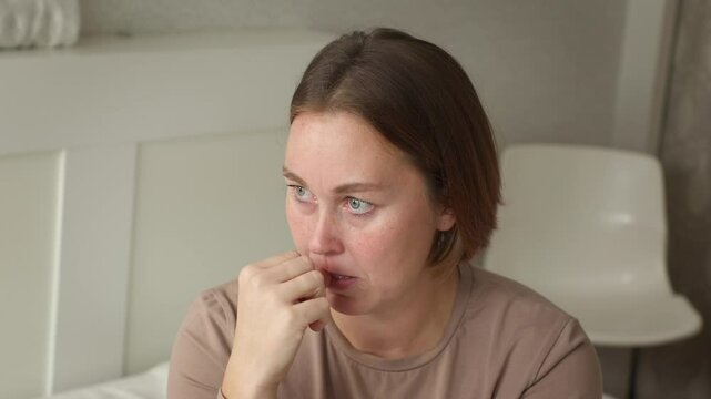 Portrait of a Caucasian nervous woman biting her nails with anxiety. The concept of psychology and mental health
