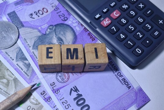 A closeup picture of the letters EMI against the Indian currency