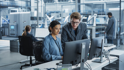 Portrait of Young Male Assembly Line Worker and Hispanic Female Engineer Collaborating on a...