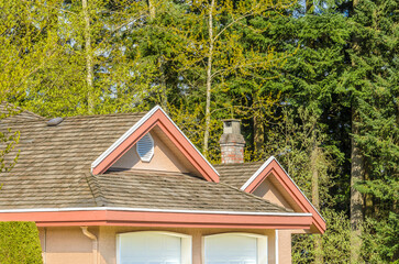 Top of grey luxury house with shingle roof, red and yellow trees and nice windows in Summer in...