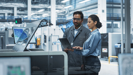 Indian Male Industrial Engineer And Hispanic Female Manager Using Laptop And Talking At Electronics...