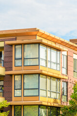 Obraz premium Top of grey luxury house with shingle roof, red and yellow trees and nice windows in Summer in Vancouver, Canada, North America. Day time on June 2024.