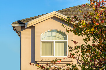 Top of grey luxury house with shingle roof, red and yellow trees and nice windows in Summer in...