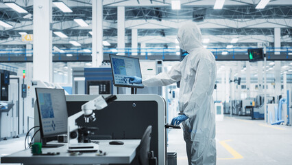 Printed Circuit Board Production At an Electronics Factory: Scientist In Sterile Suit Using...
