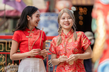Obraz premium Celebrating chinese new year joyful friends in traditional attire festive street colorful environment candid viewpoint cultural significance