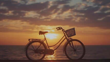 Obraz premium Silhouette of bicycle at sunset by the sea.