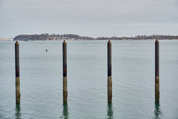 Four dock pilings sticking out of the water 