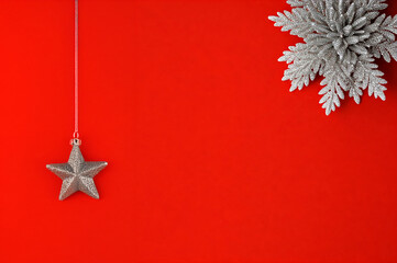 minimalist christmas design featuring a silver star ornament and frosted pine decoration on a bold red background. perfect for xmas, new year, holiday cards, and seasonal designs.