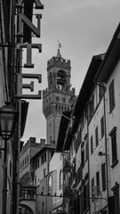 The impressive bell tower of Palazzo Vecchio dominates the view, framed perfectly between the facades of Florence’s narrow streets.