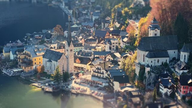 Fly over picturesque village of Hallstatt nestled in the Austrian Alps. Aerial tele shot of Evangelical Parish Church and old town in Hallstatt, Austria