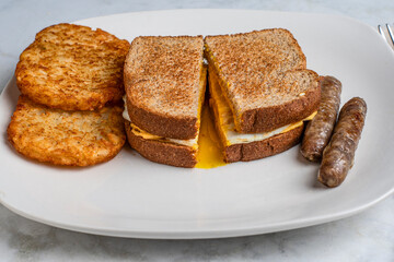 fried egg and cheese sandwich  with hash browns,