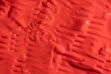 Background of plasticine like moldable material made from silicone. Red background with fork shaped...