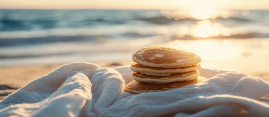 Morning pancakes beautifully arranged on a vintage white scarf with a serene beach sunset in the background