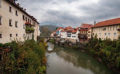 Obraz premium Captivating skofja loka reflecting on sorska river under cloudy sky