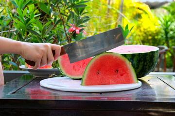 Summer berry, seedless watermelon and slices on a table on wooden terrace.