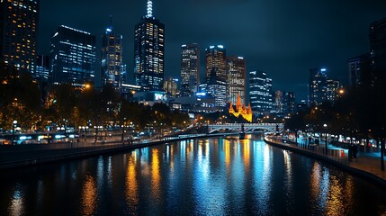Nighttime cityscape with illuminated buildings and river reflections.