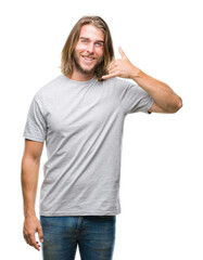 Fototapeta premium Young handsome man with long hair over isolated background smiling doing phone gesture with hand and fingers like talking on the telephone. Communicating concepts.