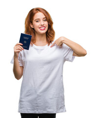 Fototapeta premium Young beautiful woman holding passport of germany over isolated background with surprise face pointing finger to himself