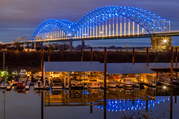 The photo showcases the illuminated Hernando de Soto Bridge spanning the Mississippi River, glowing...