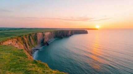 A stunning sunset over rugged cliffs, with waves lapping at the shore, creating a serene coastal landscape bathed in warm golden light.
