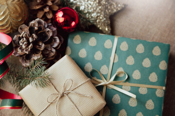 A close-up of Christmas gifts wrapped in elegant paper, surrounded by festive holiday decorations, in a retro style.