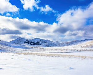 Fototapeta premium Winter landscape with snow-covered hills and dramatic clouds over a clear blue sky