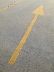 yellow arrow sign on concrete