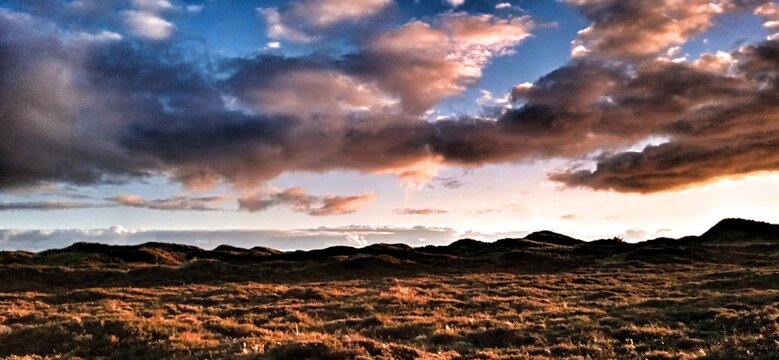 D&uuml;nenlandschaft im Abendlicht mit roten Wolken 