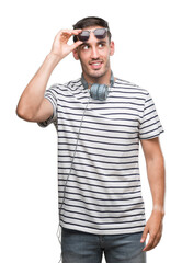 Fototapeta premium Handsome young man wearing headphones smiling looking side and staring away thinking.