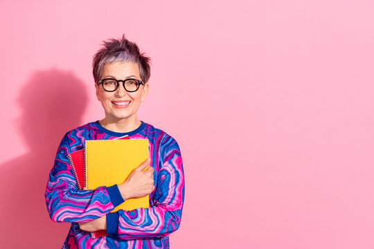 Photo portrait of pretty retired female teacher tutor hold copybooks wear blue colorful outfit isolated on pink color background