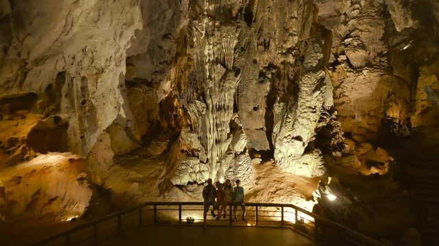 A family enjoys the stunning formations inside Phong Nha Cave, showcasing the natural beauty of Son Doong's impressive limestone structures.