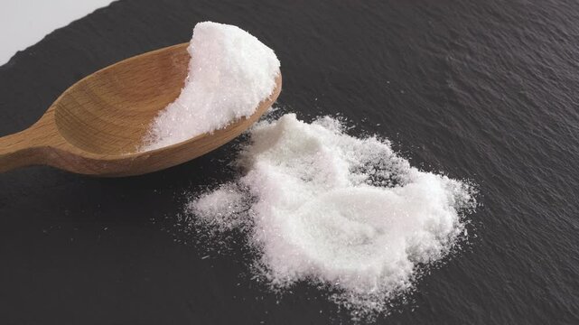 Close up of mono Monosodium glutamate (MSG)in spoon on white