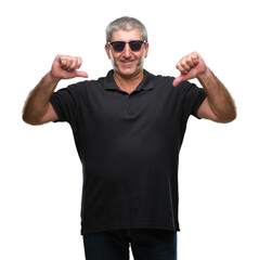 Naklejka premium Handsome senior man wearing sunglasses over isolated background looking confident with smile on face, pointing oneself with fingers proud and happy.