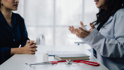 Doctor Patient Consultation:  A compassionate female doctor attentively listens to her patient...