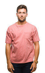 Young handsome man over isolated background with serious expression on face. Simple and natural looking at the camera.