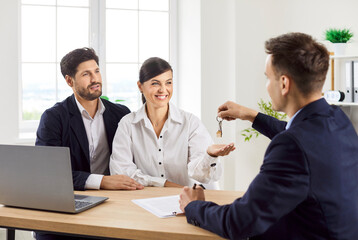 Happy family, couple receiving keys from realtor, agent to buy new own property in real estate...