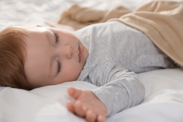 Cute little baby sleeping on bed at home