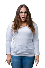 Obraz premium Beautiful plus size young woman over isolated background afraid and shocked with surprise expression, fear and excited face.