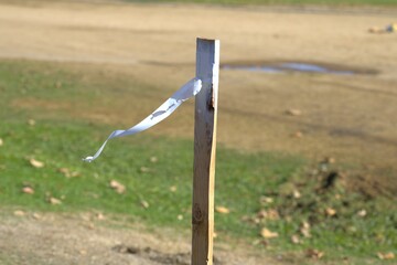 wooden post with white string tied around it waving in wind