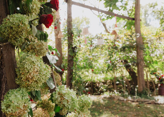 Romantic Red Roses and Green Hydrangeas on a Rustic Ladder in a Lush Woodland Setting with Hanging Lanterns