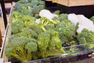 Fresh broccoli for sale in boxes in produce section of supermarket grocery store