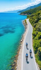 Obraz premium Scenic Coastal Road with Cyclists Riding by the Clear Blue Sea and Green Hills under a Bright Sky
