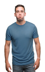 Fototapeta premium Handsome young casual man puffing cheeks with funny face. Mouth inflated with air, crazy expression.