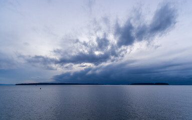 Obraz premium Dramatic Cloudy Sky Over the Calm West Coast Ocean at Sunset
